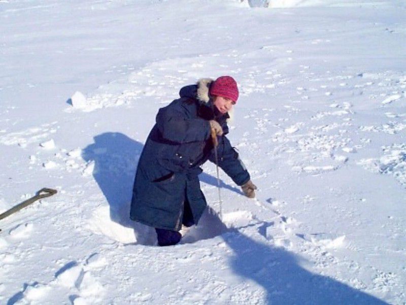 Suzanne, a volunteer teacher from Germany, cuts out a block.